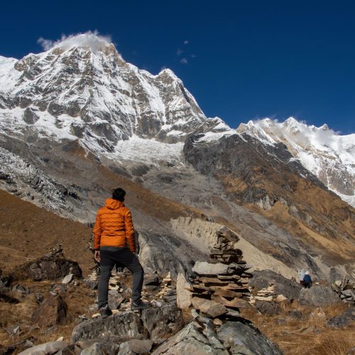 A trekker stands in awe of the majestic Annapurna mountain range in Nepal.
